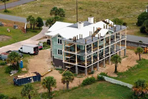 apartment building under construction with dumpster and portable toilet