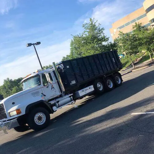 Sourgum Waste formerly Alliance Disposal roll-off truck and dumpster rental in a commercial parking lot