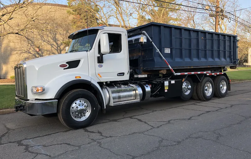 A 30 yard roll-off dumpster on a roll off truck in the street