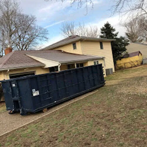 A blue roll-off dumpster in the driveway at a home in Delaware County Pennsylvania