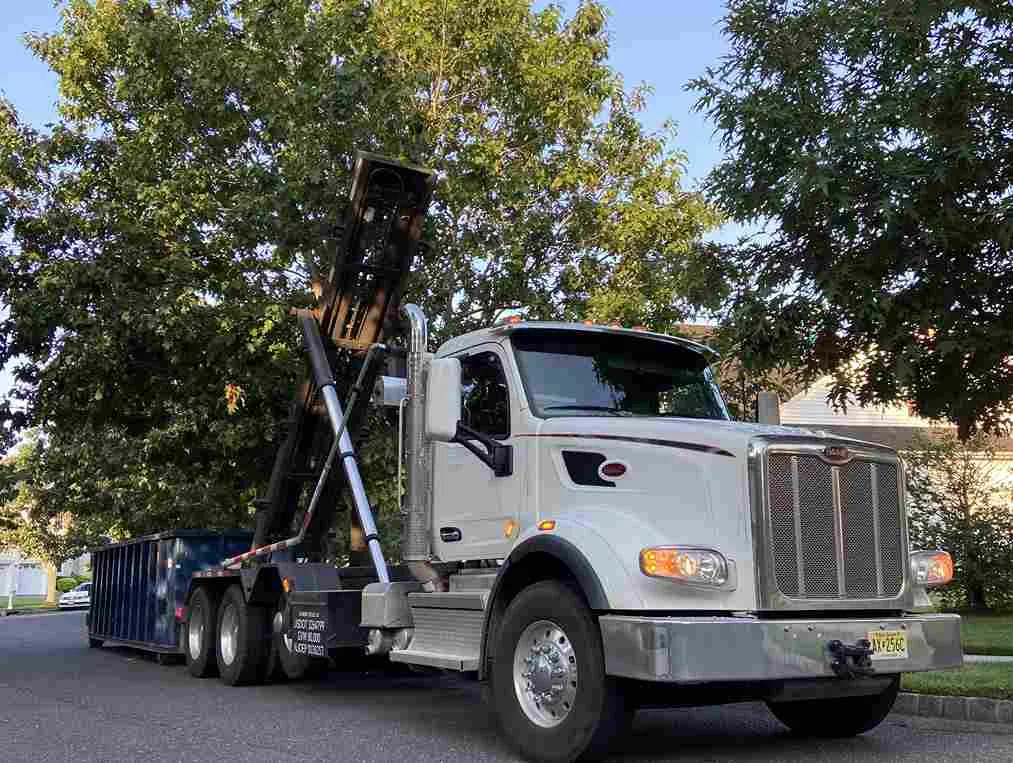 picture of roll off truck dropping bin onto cutb