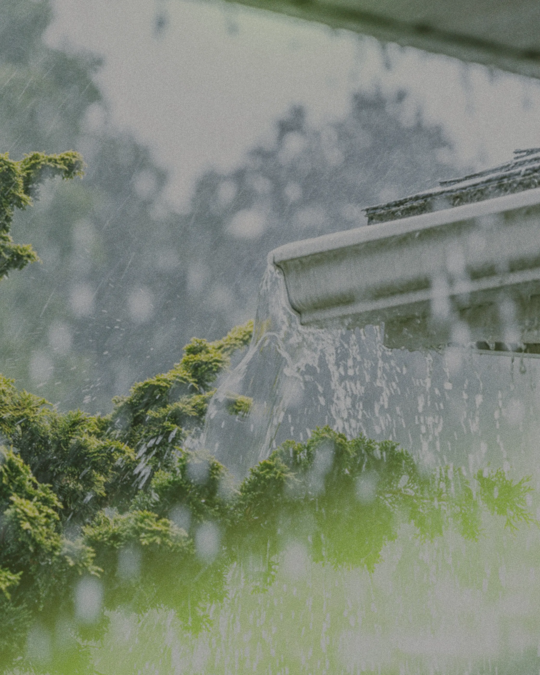heavy rain filling the gutter of a house