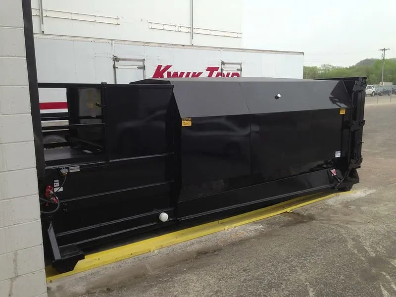 image of a black roll off compactor 
