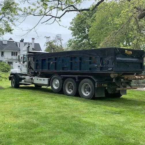 A dumpster on the grass for a dumpster delivery in Maryland