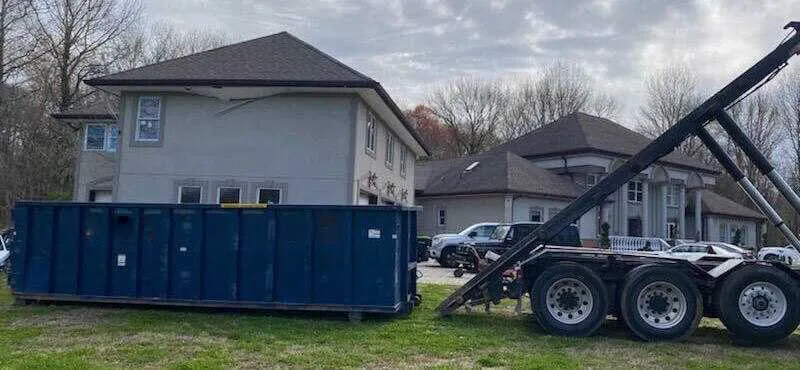 Dumpster being placed on a front lawn 