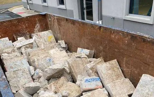 Dumpster filled with concrete bricks