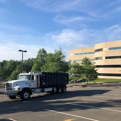 Image of roll off truck in front of building