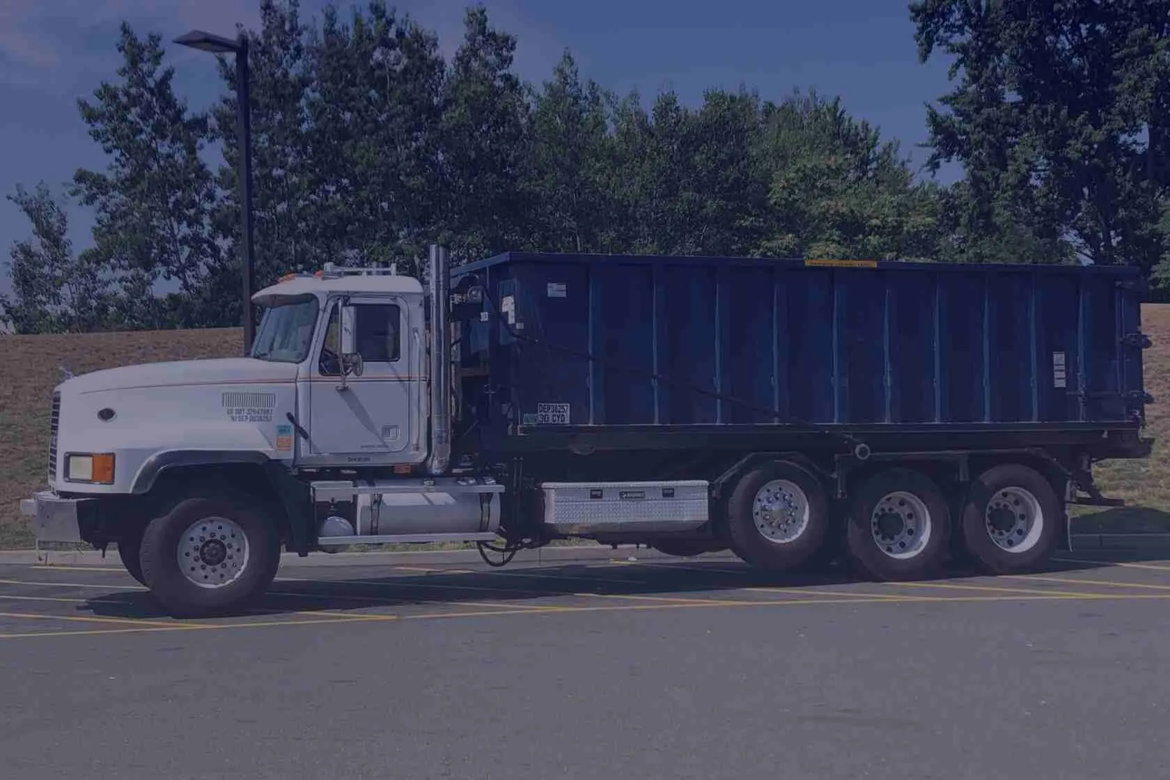blue dumpster in a roll off truck