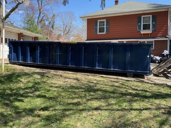 image of dumpster in front of orange house