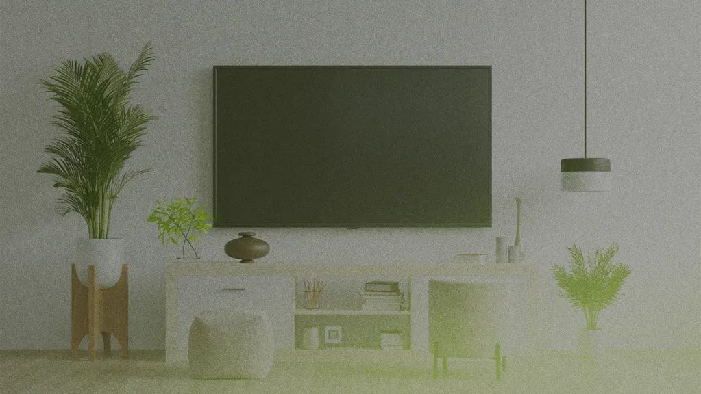 Modern living room with a large TV on a white wall, plants, a white cabinet, pouf, and a hanging light fixture. Minimalist decor.
