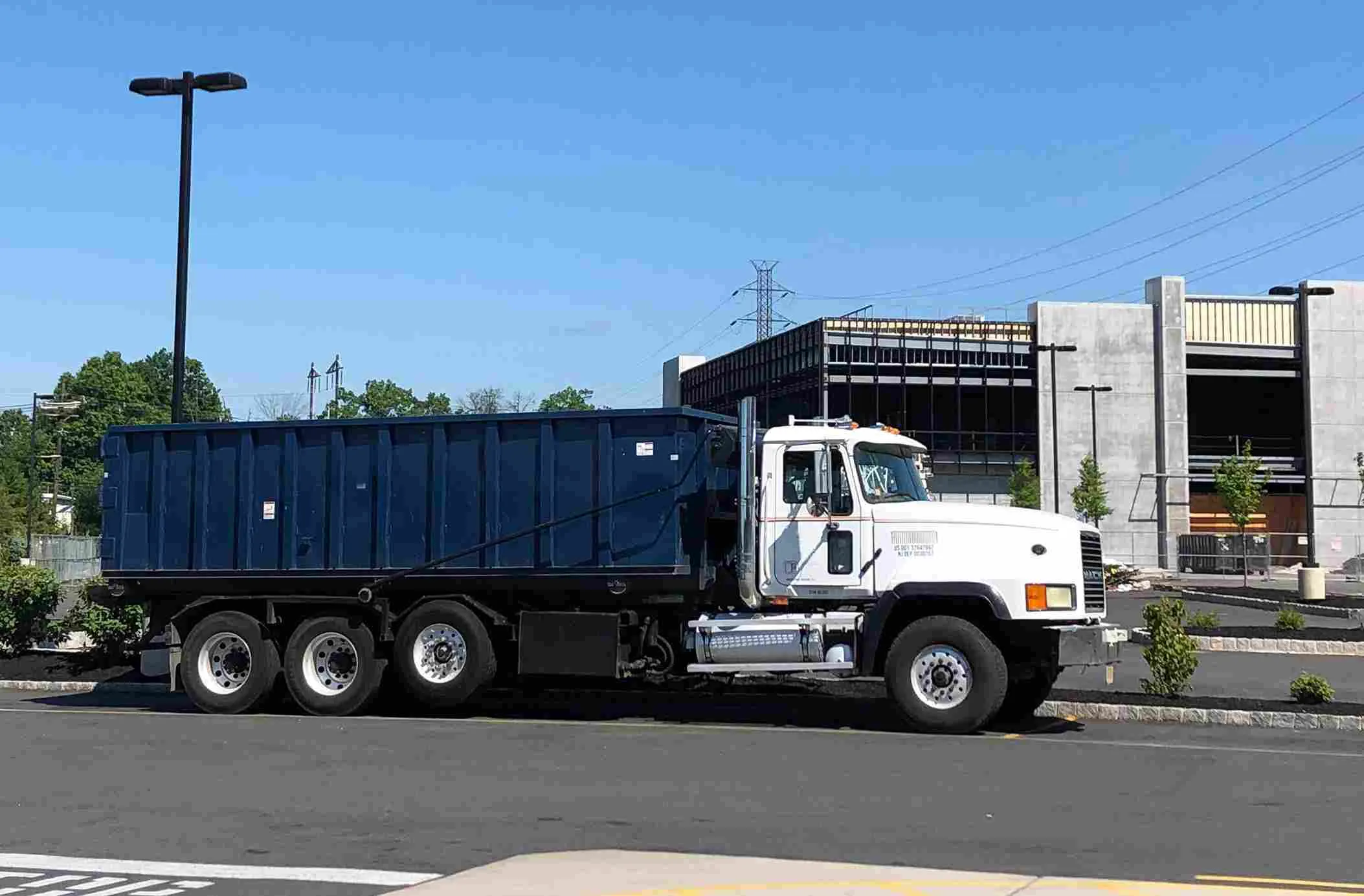 Roll off truck driving down the street 