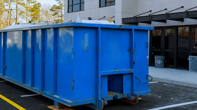 Blue 30 yard dumpster in parking lot