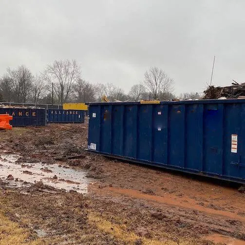 Picture of a roll off bin on a muddy jobsite 
